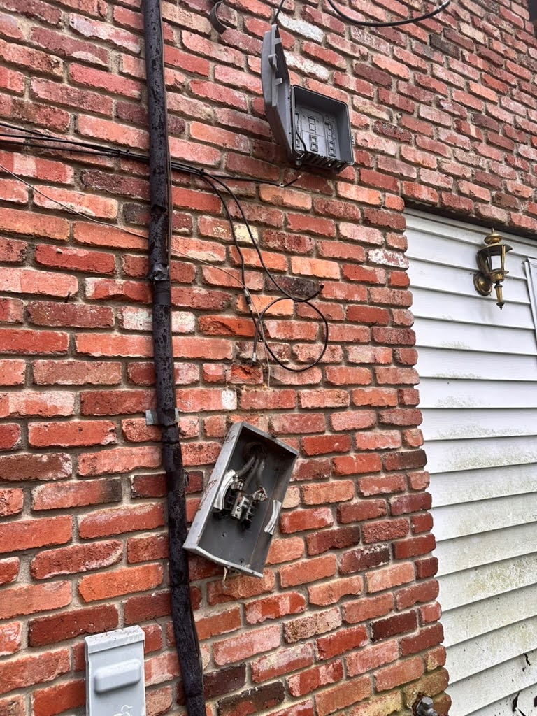 Electrician inspecting outdoor electrical wiring to prepare home for storm season, TriCities Electric